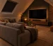 mancave op zolder met een lage bank televisie op de topgevel en steenstrips